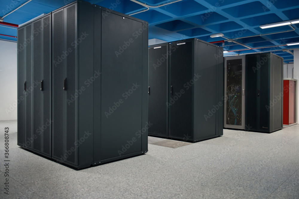 Interior of modern illuminated facility with metal server racks placed in rows Interior of modern illuminated facility with metal server racks placed in rows
