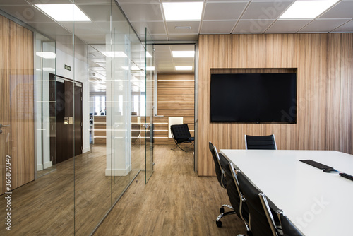 Interior of modern office with table and chairs located in room with glass walls