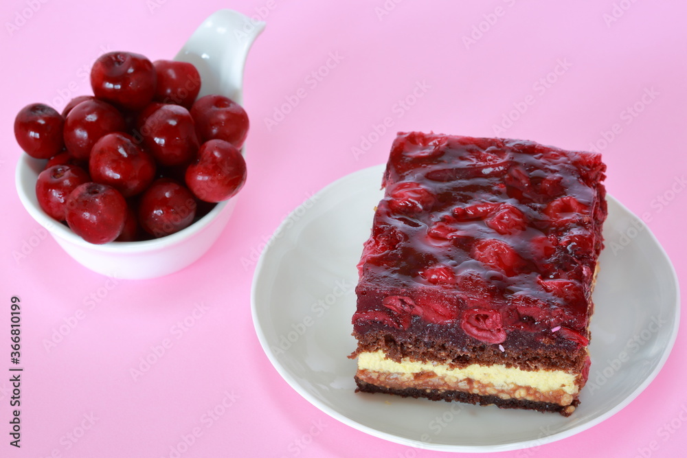 cake with cherry and bowl filled with fresh cherries close up on pink background cake with cherry and bowl filled with fresh cherries close up on pink background