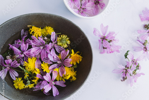 Yellow and mauve flowers in bowls on table