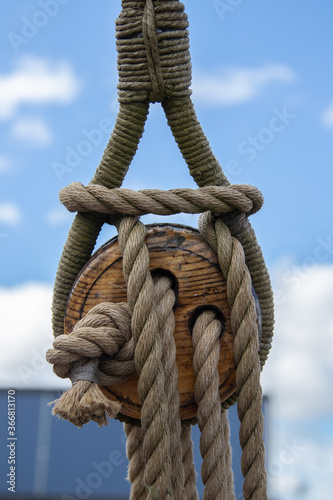 A wooden block with ropes on an old sailing ship