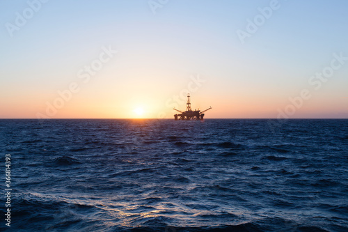 Oil rig at sunset time © Lukasz Z