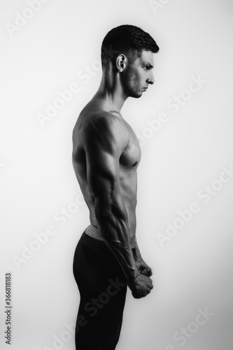 Muscle handsome young man in sportswear posing over white background. Perfect body. Studio shot © alesgon