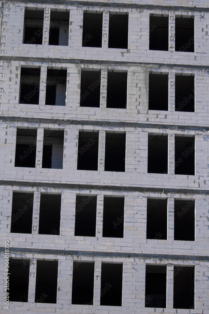 New multi-storey ready for commissioning white brick building against blue sky, free space for text