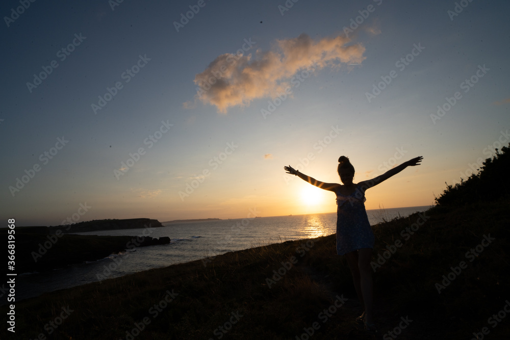 Fototapeta premium woman enjoying the sunset relaxing with a bow tie