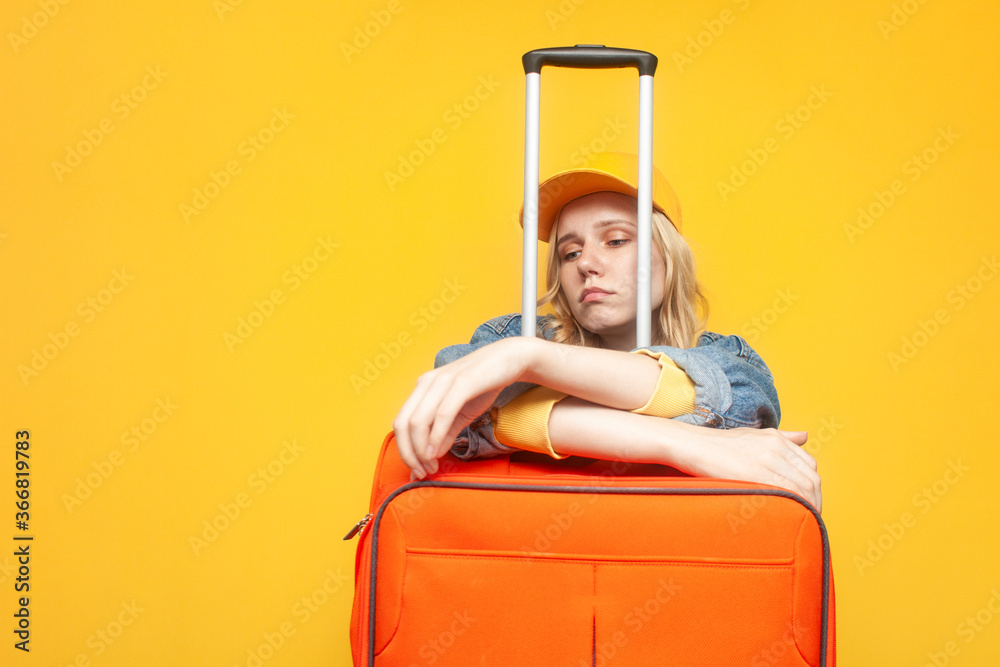 closed borders concept. unhappy girl tourist with luggage sad on yellow background, woman dreams of traveling, travel ban closed borders concept. unhappy girl tourist with luggage sad on yellow background, woman dreams of traveling, travel ban