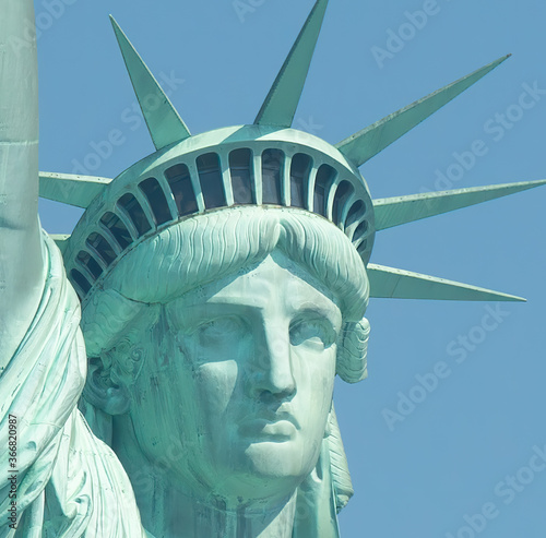 Photography Close image of statue of liberty face and crown in a sunny day with pure blue sk