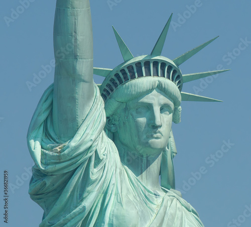 Canvas Print Close-up image of statue of liberty face and crown in a sunny day with pure blue