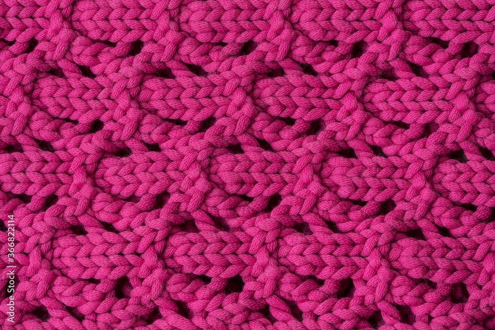 The texture of the knitted with the ornament of purple woolen fabric. Background, pattern, design. The texture of the knitted with the ornament of purple woolen fabric. Background, pattern, design.