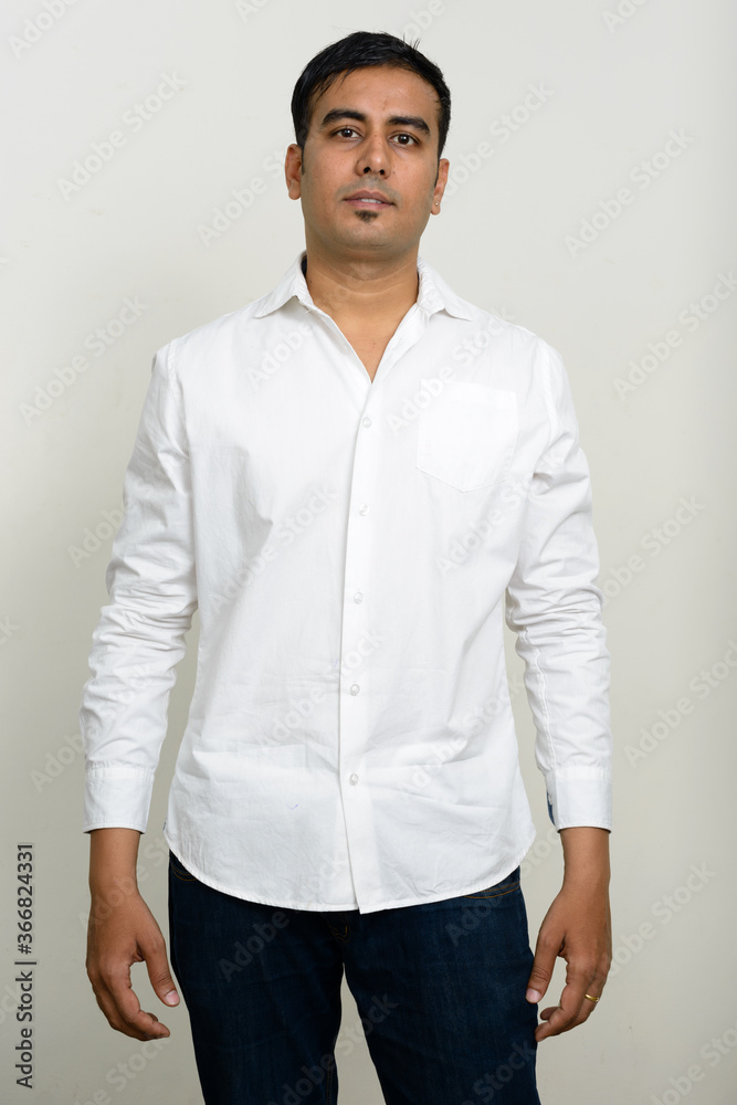 Fototapeta premium Portrait of handsome Indian businessman against white background