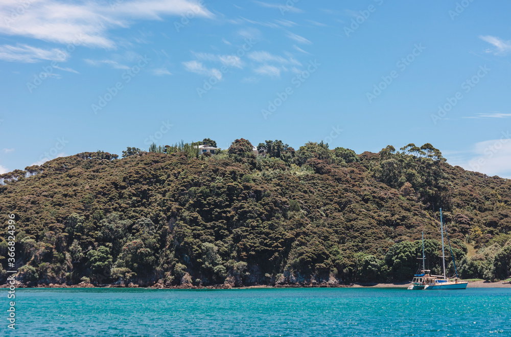 Naklejka premium Bay of Islands with sailboat at beach in New Zealand