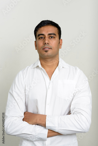 Portrait of handsome Indian businessman against white background