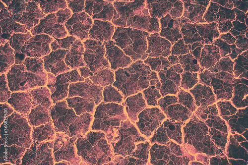 Φωτογραφία Glowing Lava Rock Texture with strong contrast black and orange tones, depicting