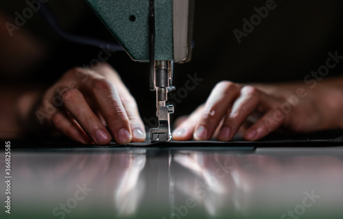 hands with a sewing machine.