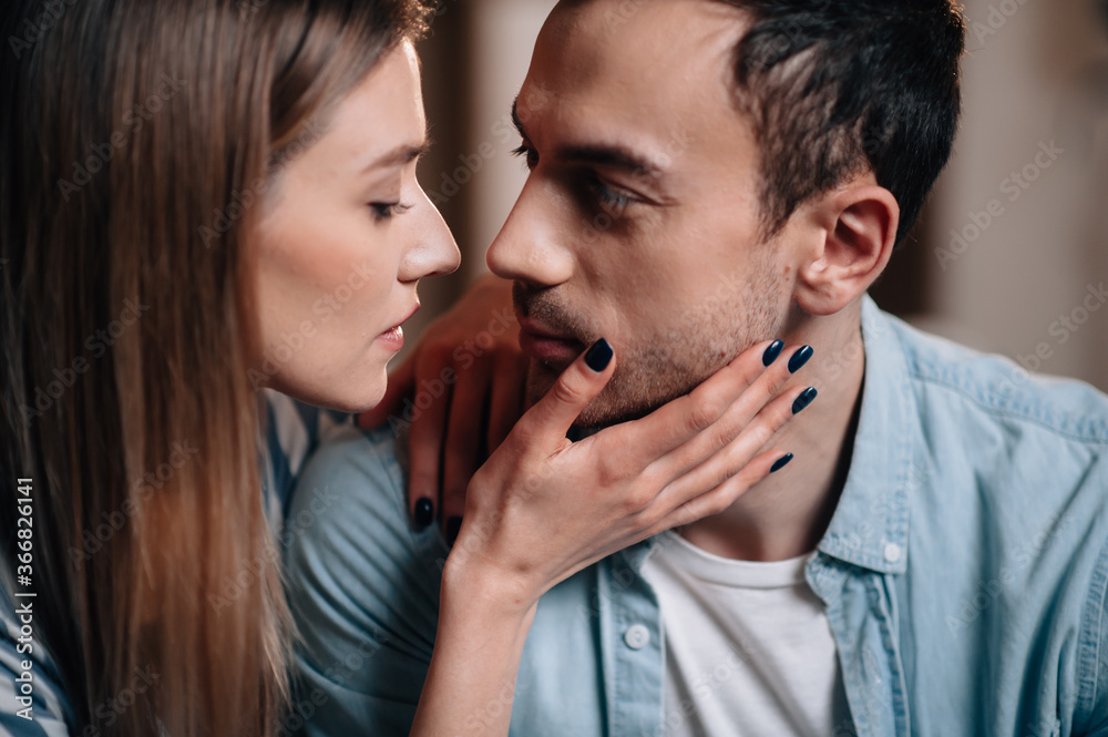 Portrait of a young couple in casual clothes on the couch in hugging each other Portrait of a young couple in casual clothes on the couch in hugging each other