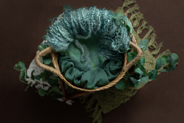 wicker basket for newborn photo sessions. props for the photo shoot are decorated with eucalyptus leaves. background for a newborn photo shoot