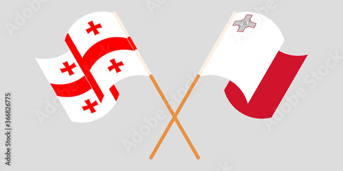 Crossed and waving flags of Malta and Georgia
