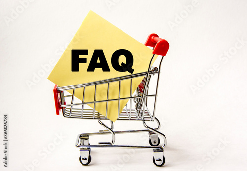 Shopping cart and text FAQ on white paper note list. Shopping list, business concept on white background.