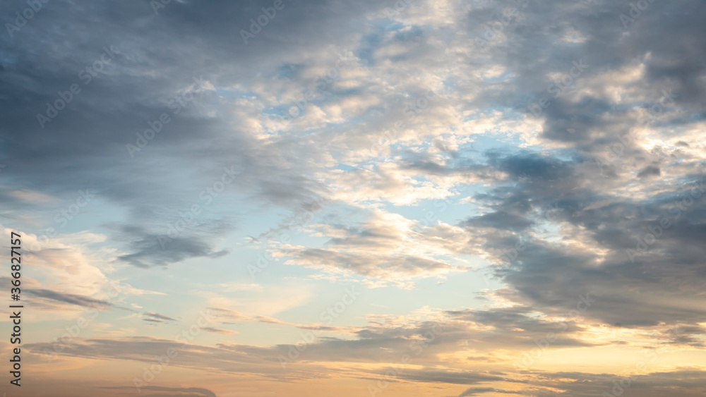 sun sets behind the clouds in the blue evening sky as a natural background sun sets behind the clouds in the blue evening sky as a natural background