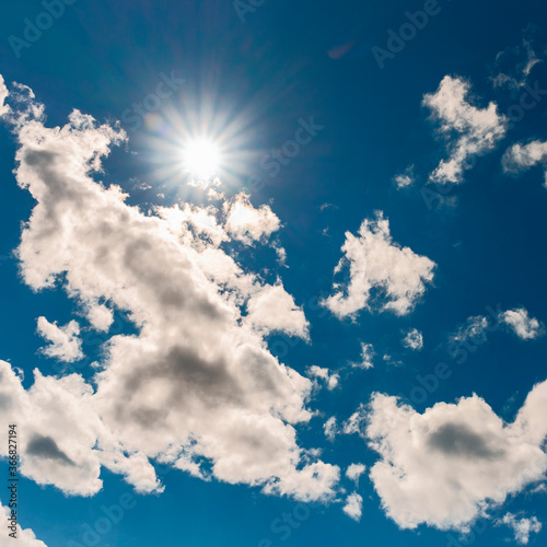 blue sky with white clouds and bright sun as a natural background.