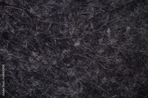 Texture of cotton jersey boiled, black and gray spotted. Background, close-up.