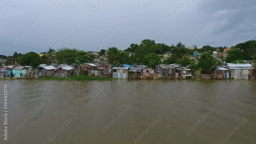 Aerial, drone shot towards slum houses and homes on the coast of the Rio Ozama river, in Santo Domingo, Dominican Republic