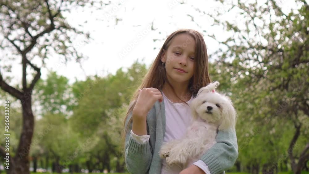 Little smiling girl playing with puppy in the park Little smiling girl playing with puppy in the park