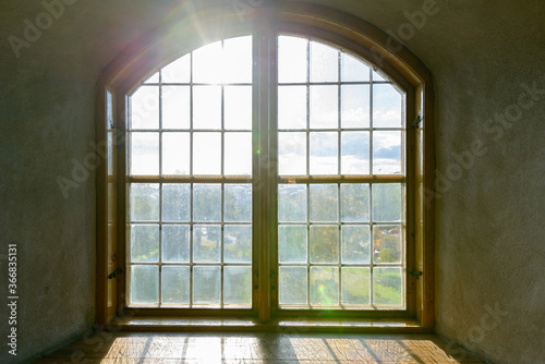 Closed wooden vintage window cemented on brick wall with natural view and sunlight streaming in