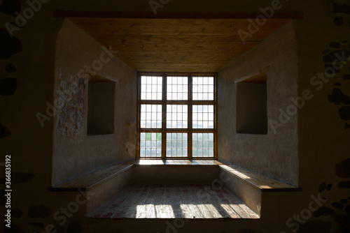 Portrait of closed wooden window and ceiling with sunlight streaming in