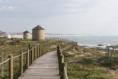 Windmills and coastal path at beach Praia da Apúlia, Esposende, Portugal