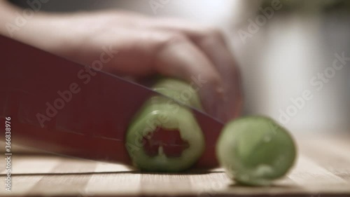 Green bell pepper being cut in kitchen photo