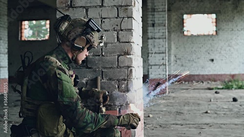 Funny fail moment of a military man with assault rifle during combat in a building, lost ammunition clip after throwing smoke grenade.