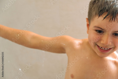 child playing with shower in bathroom
