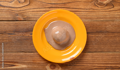 half melted chocolate ice cream ball on a dish
