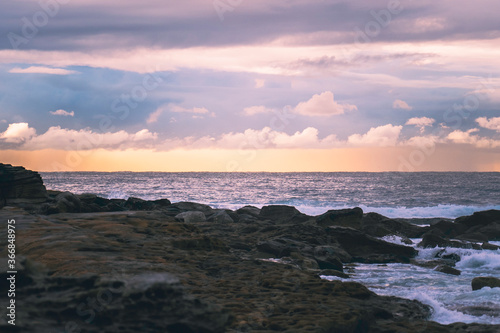 Sunrise over rocks at beach  landscape  room for copy  room for text  background landscape image