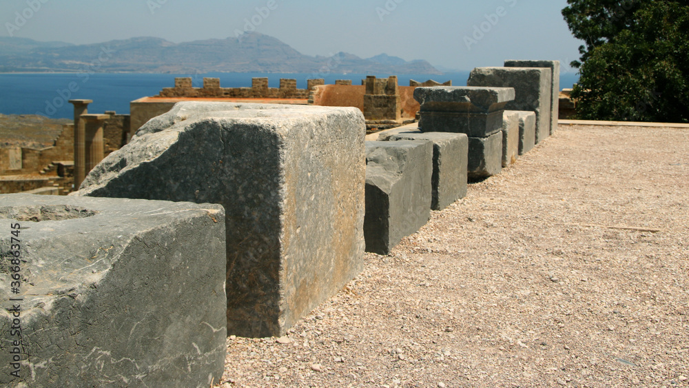 Stone bases of statues, the Acropolis of Lindos, Greece. The dedications in Greek glorify the gods Stone bases of statues, the Acropolis of Lindos, Greece. The dedications in Greek glorify the gods