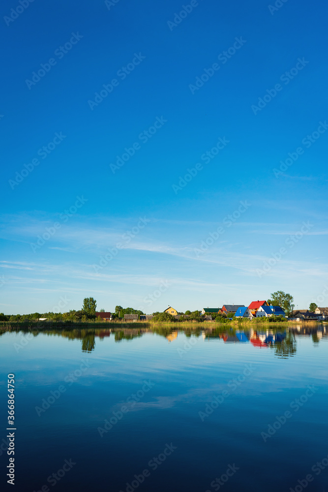 Small village, houses reflection in the lake Seliger
