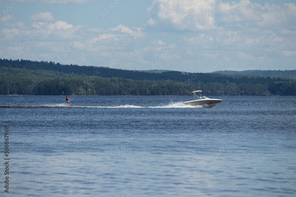 Obraz premium Person water skiing behind big boat on Round Lake, Ontario, Canada 