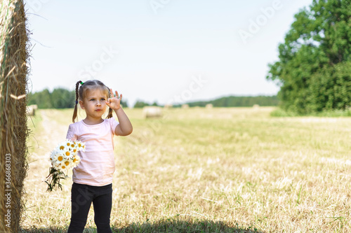 little girl with a bouquet of wildflowers in a summer field