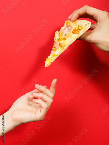 hand reaches for pizza on red background
