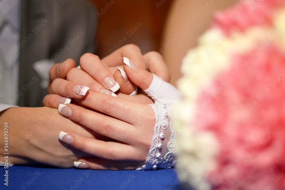 Bride's hands with manicure hugs the groom's hands Bride's hands with manicure hugs the groom's hands