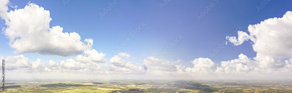 summer rural landscape under blue sky with fluffy clouds. panoramic aerial view of picturesque agricultural fields summer rural landscape under blue sky with fluffy clouds. panoramic aerial view of picturesque agricultural fields