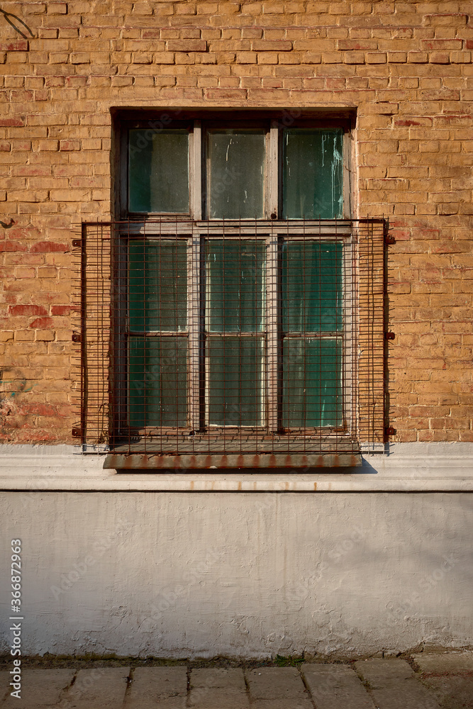 old barred window on a brick wall