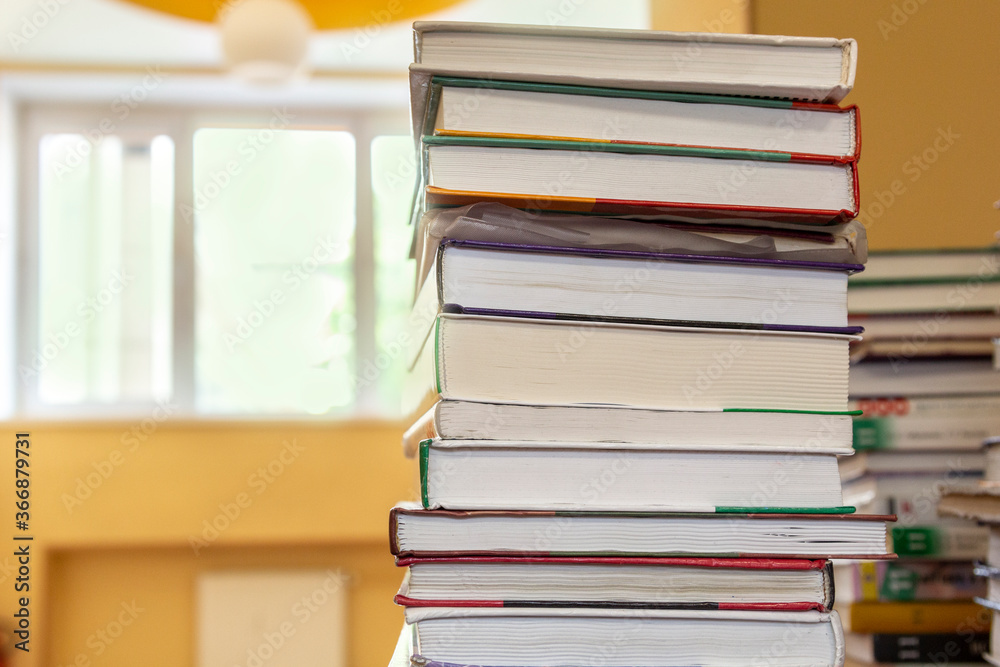 Stack of books on table in school library on blurry background. Concept back to school. Close-up, copy space Stack of books on table in school library on blurry background. Concept back to school. Close-up, copy space