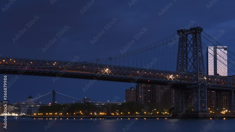 View on Williamsburg bridge from East river with a night to day time lapse. View on Williamsburg bridge from East river with a night to day time lapse.