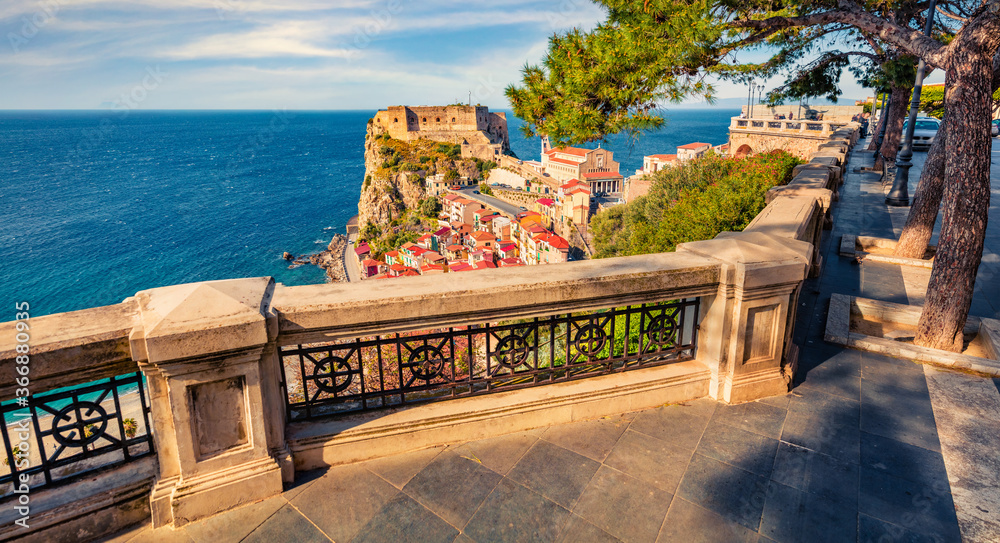 Fototapeta premium Bright spring view of Scilla town with Ruffo castle on background, administratively part of the Metropolitan City of Reggio Calabria, Italy, Europe. Colorful morning seascape of Mediterranean sea.