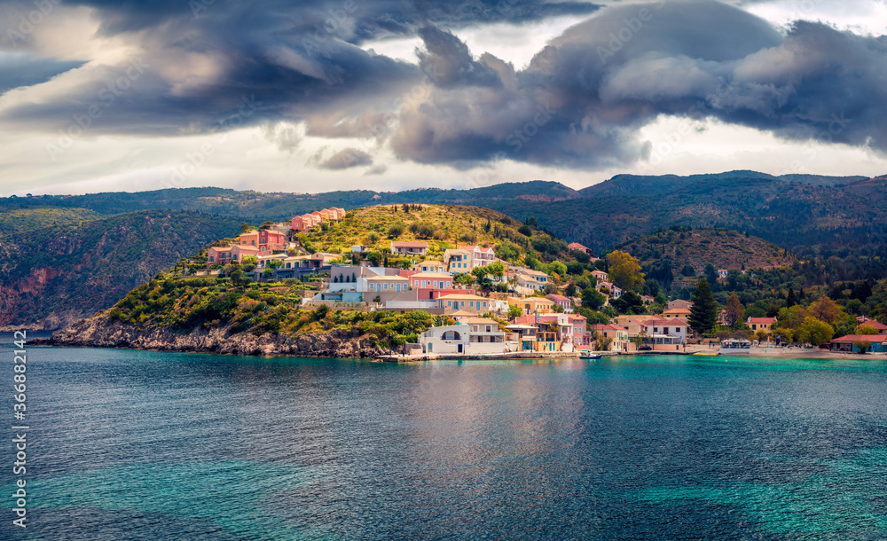Dramatic morning cityscape of Asos village on the west coast of the island of Cephalonia, Greece, Europe. Gloomy summer sescape of Ionian Sea. Traveling concept background.