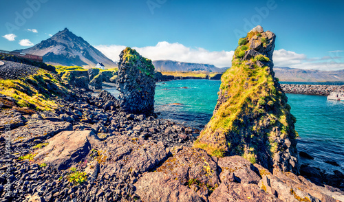 Astonishing summer view of small fishing village at the foot of Mt. Stapafell - Arnarstapi or Stapi. Attractive morning scene of Icelandic countryside. Traveling concept background. photo