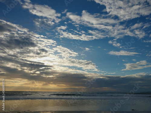 yellow sunrise beach paradise white sandy dramatic ocean blue sky cloud and rough blue water