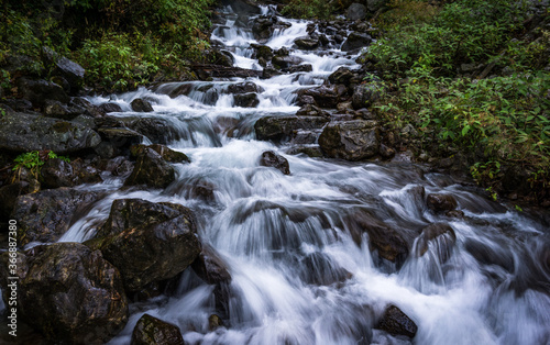 Fototapeta Naklejka Na Ścianę i Meble -  A waterfall amid foliage in Langtang National Park in Nepal. Freshwater source.